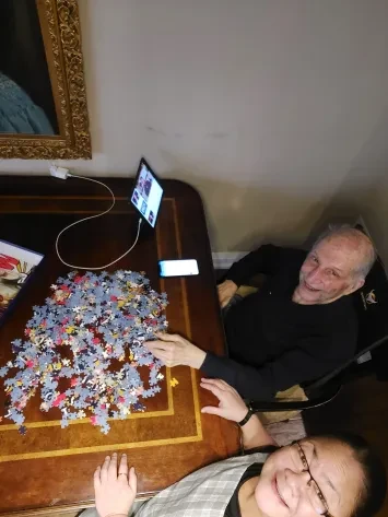 Senior client and caregiver working on a puzzle together