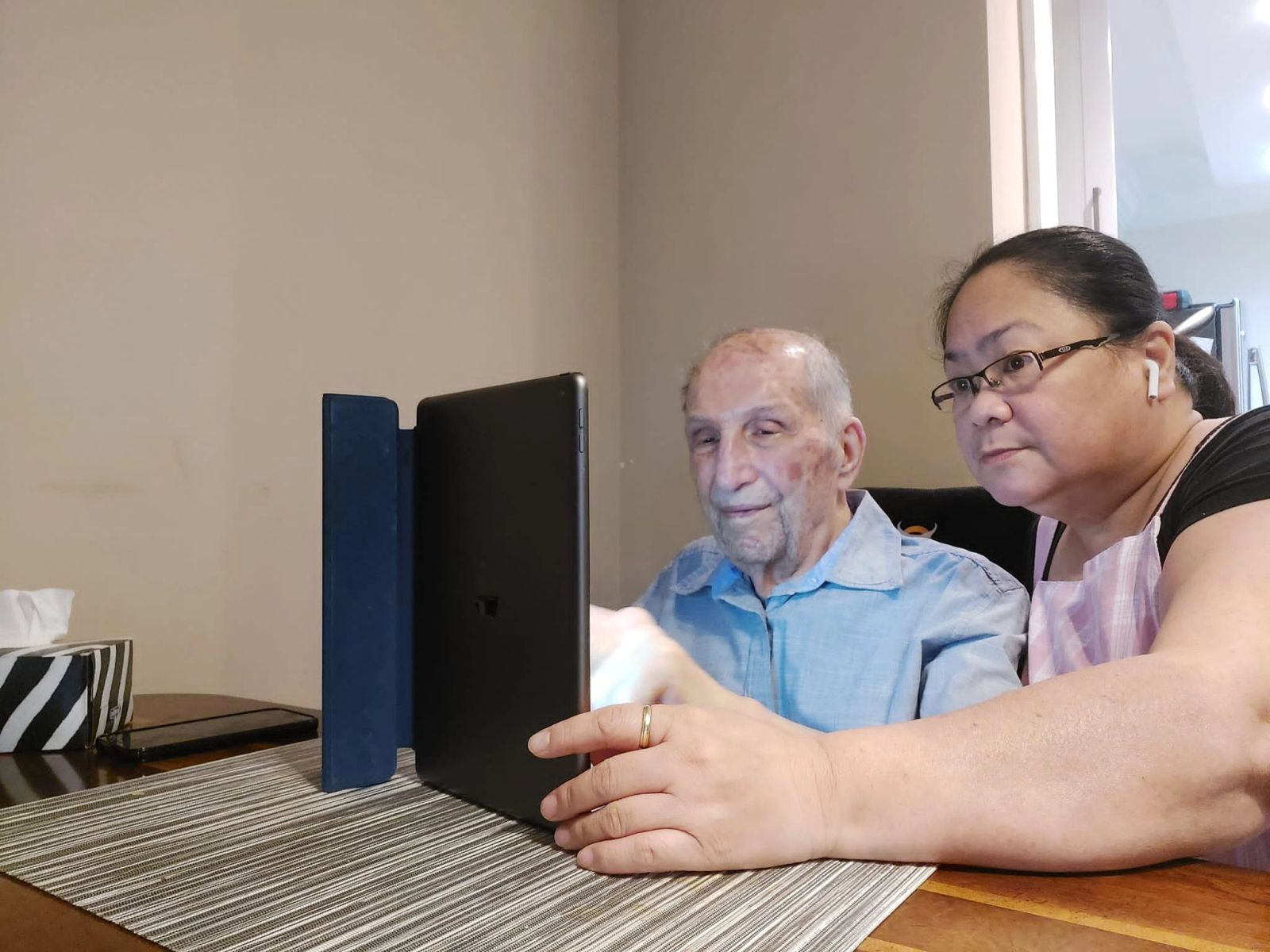 A caregiver and a beloved client enjoying time together on a tablet